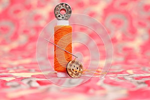 Photo of sewing thread, bobbin and button