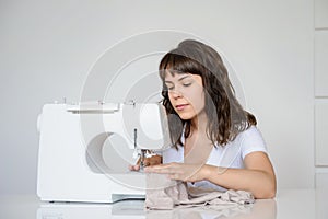 Photo of a sexy brunette working at the sewing machine