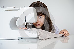 Photo of a sexy brunette working at the sewing machine