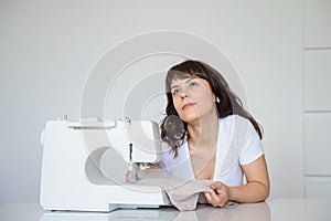 Photo of a sexy brunette working at the sewing machine