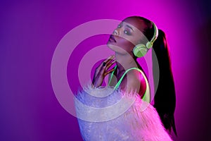 Photo of shiny adorable lady dressed fur coat headphones enjoy melody empty space isolated purple color background