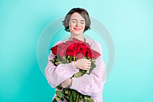 Photo of shiny dreamy woman wear violet sweater embracing huge bouquet roses closed eyes  turquoise color
