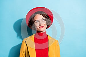 Photo of shiny dreamy young woman dressed red headwear jacket smiling looking empty space isolated blue color background
