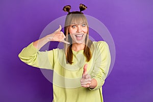 Photo of shiny funky young woman dressed green pullover ask call her pointing finger you isolated purple color