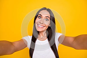 Photo of shiny funny young woman dressed white t-shirt tacking selfie smiling isolated yellow color background