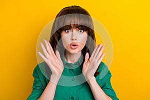 Photo of shiny impressed lady wear green shirt big eyes rising arms hands isolated yellow color background