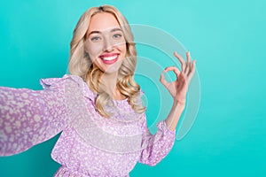 Photo of shiny sweet woman dressed purple blouse showing okey recoding self video isolated teal color background