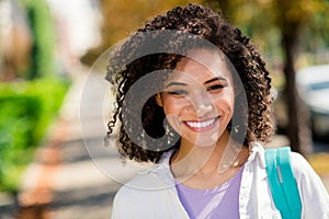 Photo of shiny toothy lady wear white shirt rucksack enjoying sunny weather tourism outside urban city park