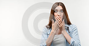 Photo of Shocked girl in casual clothes, covering mouth with hands. Keep silence concept. Copy space