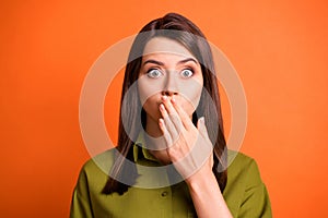 Photo of shocked young girl hand cover mouth staring camera wear green shirt  orange color background