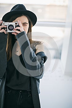 Photo shooting. Stylish beautiful girl holding the retro style cam
