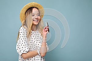 Photo shot of attractive happy smiling young blonde woman wearing summer casual clothes and stylish sunglasses isolated