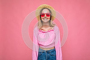 Photo shot of beautiful positive young blonde woman wearing summer casual clothes and stylish sunglasses isolated over