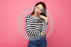 Photo shot of cute attractive pretty young brunette woman wearing casual striped longsleeve isolated over colorful