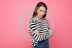 Photo shot of nice attractive pretty young sad upset brunette woman wearing casual striped longsleeve isolated over