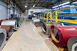 Photo shot of roll of painted galvanized steel sheet at cutting machine, ironworks and metalwork in factory. Plant