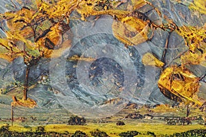 Photo shows mountains with yellow abstract frame. Rocky landscape looks chaotic, stormy, and shows world upended.