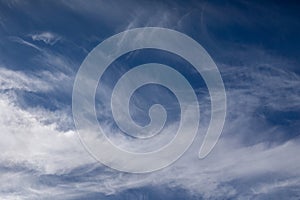 Wispy cirrus clouds spread across a blue sky. Natural cloud patterns creating a light atmosphere.