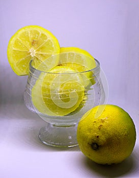 Photo of lemons cut in a glass bowl  over a white background photo