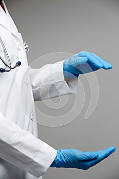 Photo on side of doctor in white coat w holding hands in form of circle isolated on gray background.