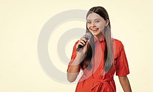 photo of singer teen girl hold microphone, copy space. teen girl singer singing with microphone