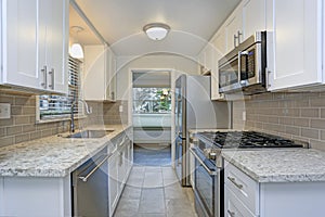 Photo of a small compact kitchen with white shaker cabinets