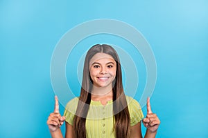 Photo of small lady indicate forefingers up empty space novelty wear green top isolated blue color background photo