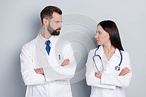 Photo of smart clever two docs dressed white uniform sarms folded looking each other isolated grey color background