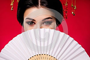 Photo of sophisticated elegant lady hiding face japanese fan traditional isolated on red gradient color background