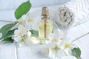 Photo for a spa center with a jar of jasmine oil and jasmine flowers. Aromatherapy and oil for massage. Cosmetic oil jasimna