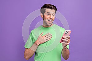 Photo of speechless lucky man astonished staring at smartphone facebook twitter instagram whatsapp isolated on purple