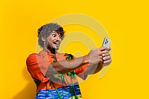 Photo of speechless man dressed print shirt staring at impressive internet speed on smartphone isolated on yellow color