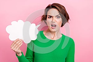 Photo of speechless stupor girl dressed green sweater holding speaking cloud empty space isolated pink color background