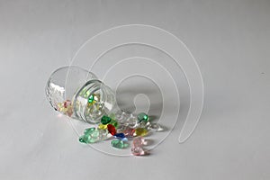 Photo of spilled transparant jar with colorful gems toy