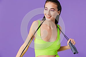 Photo of sporty joyful woman holding jump rope and smiling