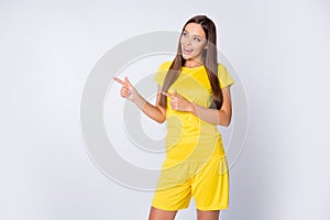 Photo of sporty shapes sexy lady indicate fingers side empty space advising sports equipment shop wear yellow football