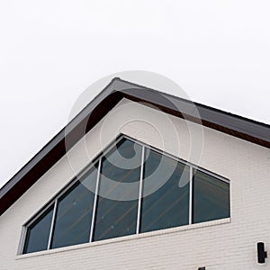 Photo Square frame Home exterior with tringular window and white wall under gable roof