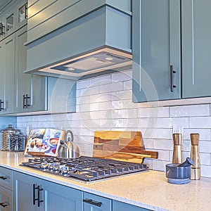 Photo Square Kitchen with white counter top and bluish gray cabinets against tile backsplash