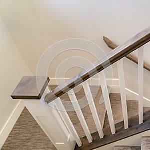 Photo Square U shaped indoor staircase of home with treads and landing covered with carpet