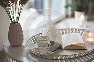 Photo of stylish white tray with black koffee and dark chocoltte and a book