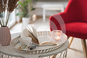 Photo of stylish white tray with black koffee and dark chocoltte and a book