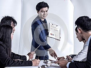Photo of successful businessman sharing ideas by whiteboard with partners at presentation