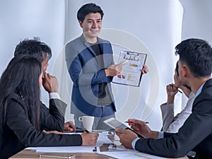 Photo of successful businessman sharing ideas by whiteboard with partners at presentation