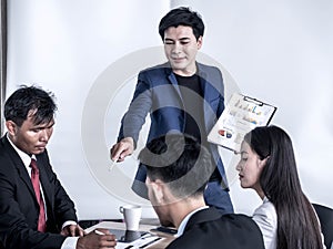 Photo of successful businessman sharing ideas by whiteboard with partners at presentation