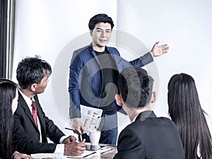 Photo of successful businessman sharing ideas by whiteboard with partners at presentation