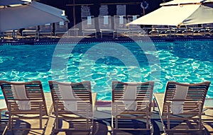 Photo of Sunloungers by swimming pool photo