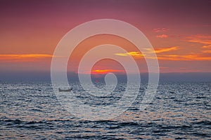 A photo of a sunset landscape where the sea is reflected in the orange light and the blue water is refreshing. At Bang Tao Beach,