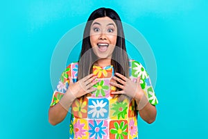 Photo of surprised young japanese woman wear trendy flowers colorful print t-shirt hands heart thankful isolated on cyan