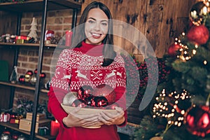 Photo of sweet beautiful young woman dressed red sweater decorating new year tree smiling indoors room home house