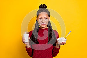 Photo of sweet charming dark skin lady wear red pullover smiling holding cottagecheese milk glass isolated yellow color